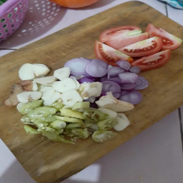 Iris tipis tomat, bawang merah, bawang putih, cabai rawit dan lengkuas.