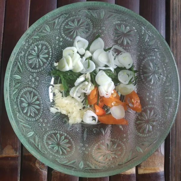 Haluskan bawang putih, rajang halus cabai dan daun bawang, masukkan kedalam mangkok.