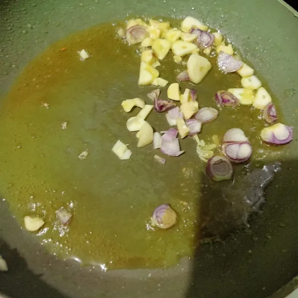 Siapkan wajan lain lalu beri minyak sedikit. Tumis irisan bawang merah dan bawang putih sampai tercium harum