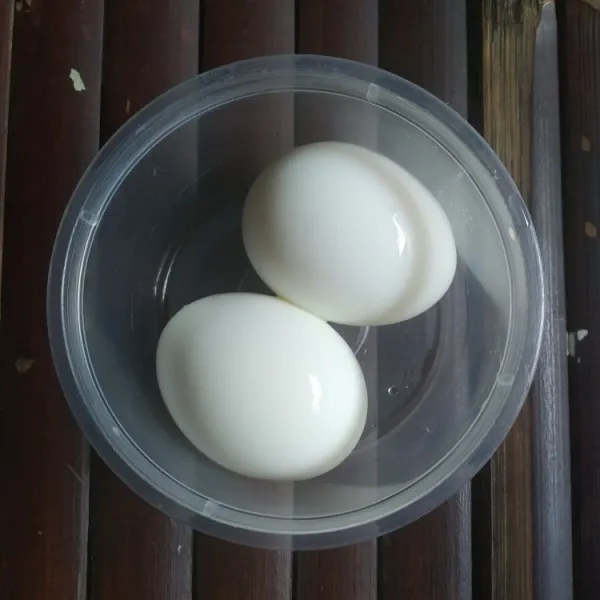 Kupas telur rebus, kemudian masukkan dalam wadah.