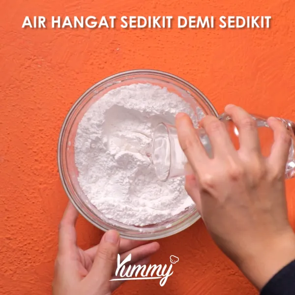 Tuangkan air hangat sedikit demi sedikit sambil diaduk dengan tangan. Pastikan adonan menjadi lembab berpasir, jika sudah mencapai konsistensi tersebut, artinya adonan sudah siap.