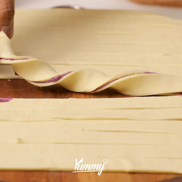 Tumpuk dengan kulit puff pastry yang lainnya lalu gulung hingga berbentuk spiral.