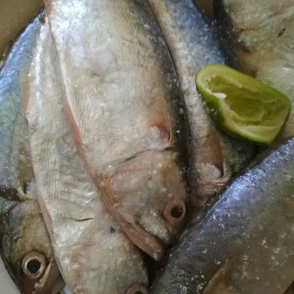 Cuci bersih ikan kemudian beri perasan jeruk nipis dan garam, saya potong dua ikannya