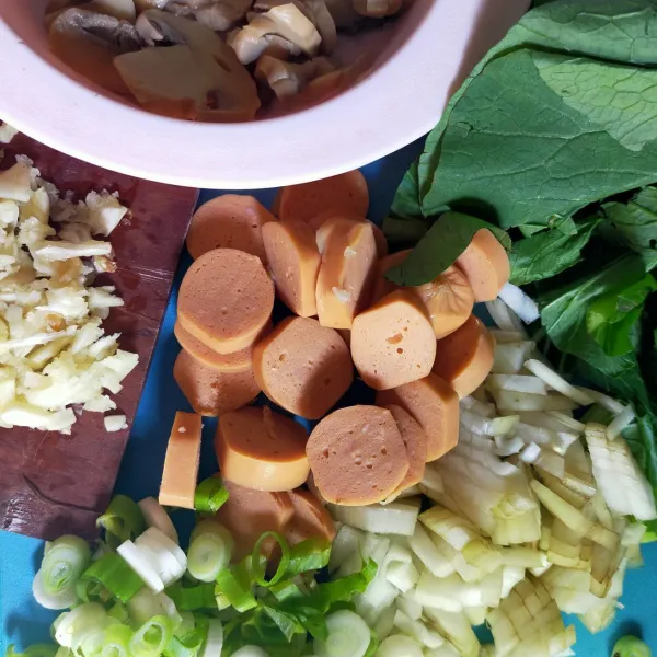 Siapkan semua bahan,bersihkan ayam dan potong kotak-kotak, geprek bawang putih, iris bawang bombay dan daun prei. Potong-potong sawi dan sosis.