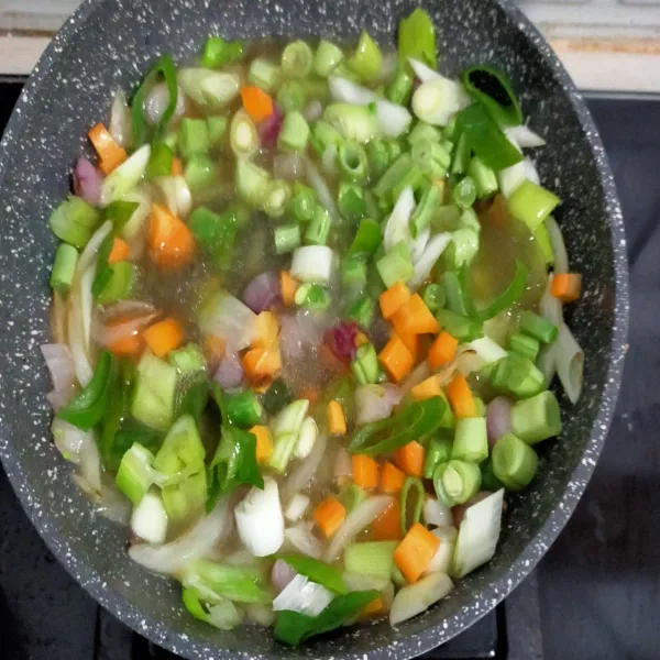 Setelah berbau harum, masukkan wortel,  buncis, daun bawang dan kaldu ayam.