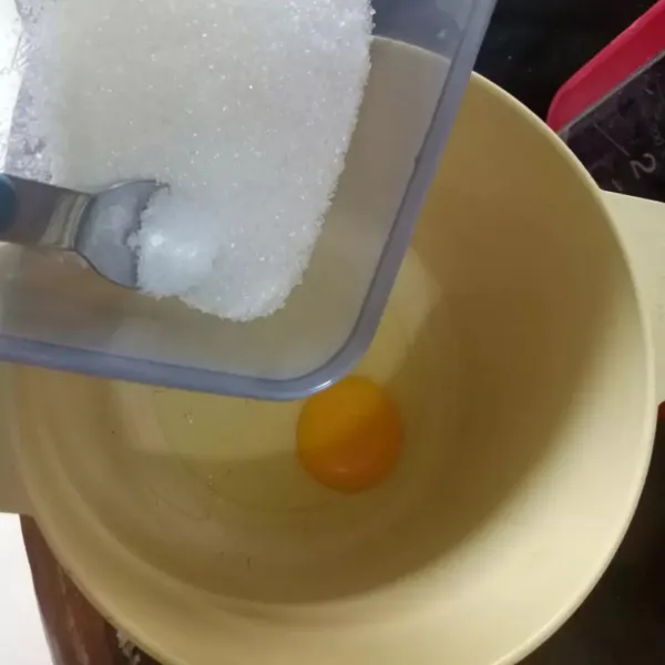 Pecahkan telur ke dalam wadah lalu masukkan gula pasir.