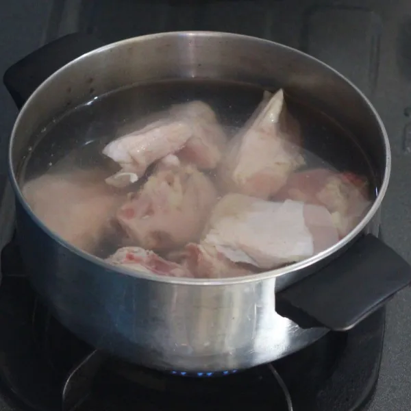 Rebus ayam dengan air di panci terpisah.