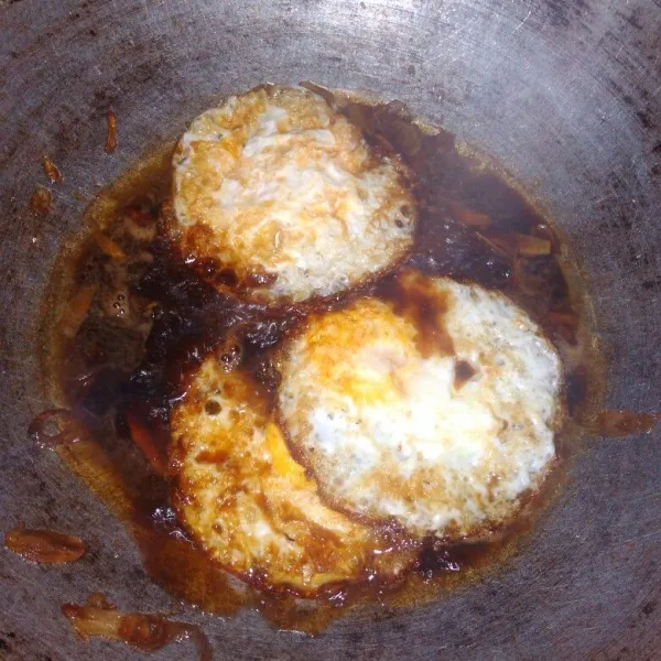 Masukkan telur mata sapi, garam, gula dan sedikit air, tes rasa. Masak sampai kuah agak meresap kedalam telur. Angkat dan sajikan.