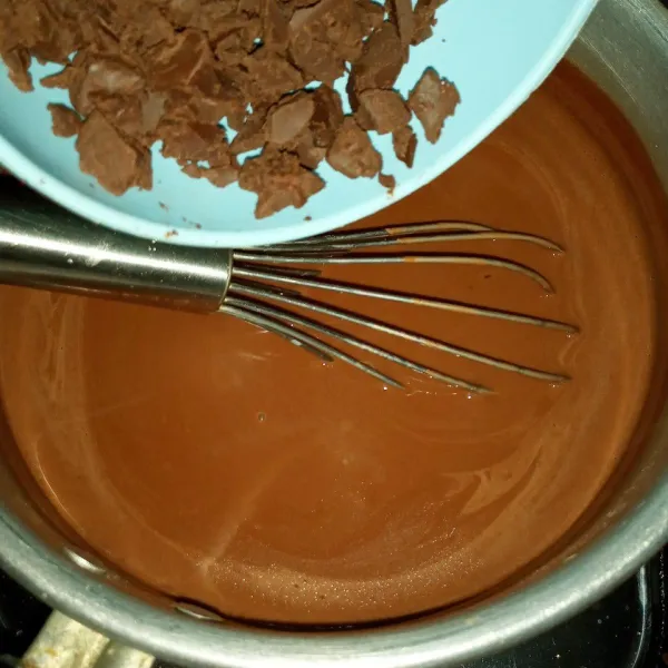 Masukan coklat pekat dan whipped cream, aduk terus sampai coklat cair. Matikan api.