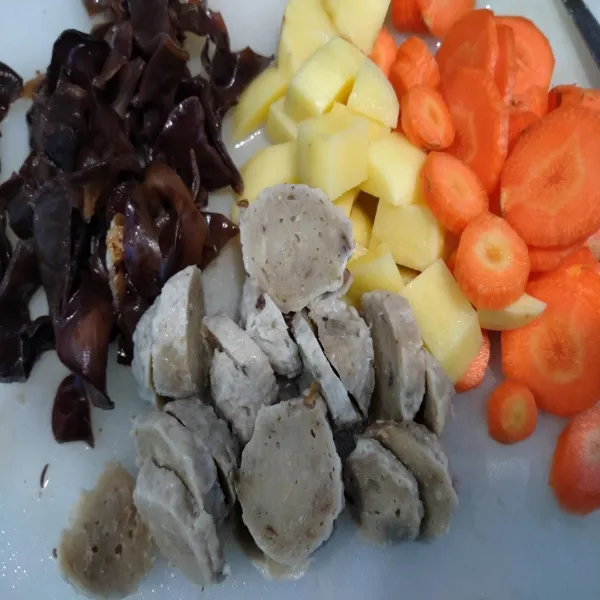 Potong-potong bakso, kentang, wortel, dan jamur kuping sesuai selera.