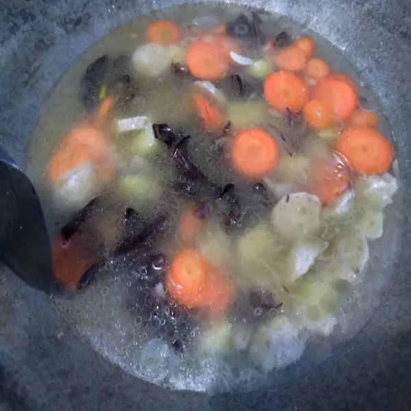 Lalu masukkan wortel dan jamur kuping. Beri merica dan kaldu bubuk. Aduk rata.