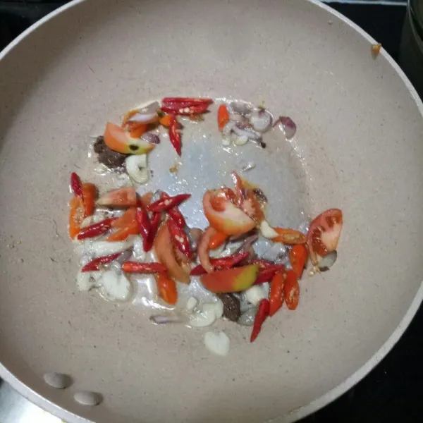 Masukan cabai dan potongan tomat. Aduk hingga tomat mengeluarkan sari-sarinya. Tambahkan garam, gula dan penyedap rasa. Bila sudah harum, tambahkan 3 sdm air untuk melarutkan bumbu-bumbu.