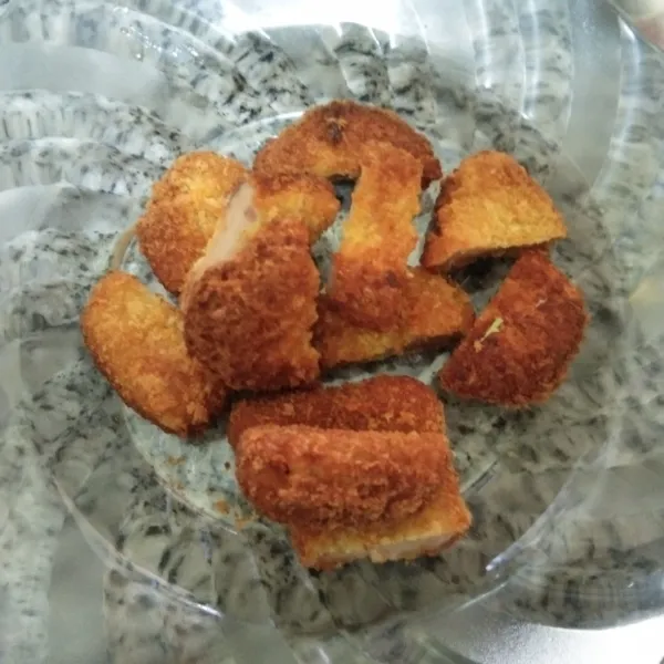 Goreng nugget ayam, tiriskan potong-potong sesuai selera