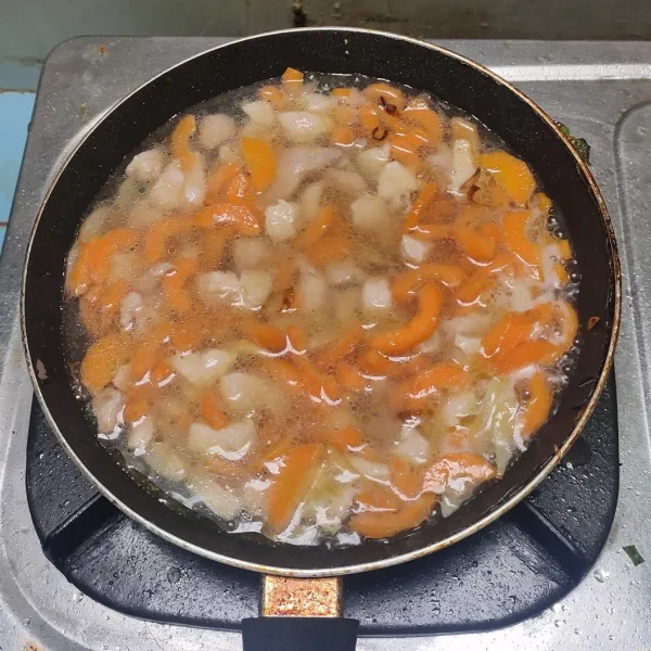 Masukkan wortel dan ayam, aduk-aduk sebentar dan tambahkan segelas besar air. Biarkan mendidih.