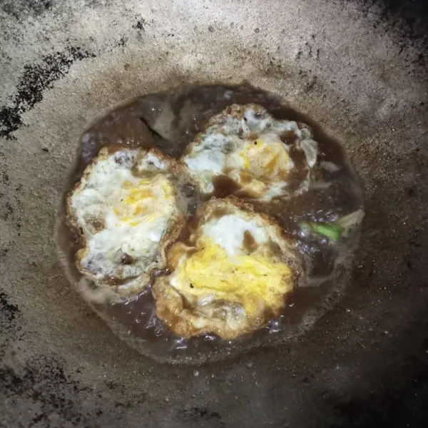 Masukkan telur ceplok dan masak hingga bumbu meresap dan kuah berkurang.