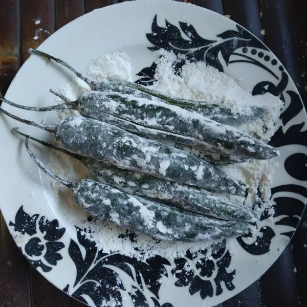 Lumuri cabai dengan tepung terigu, sisihkan.