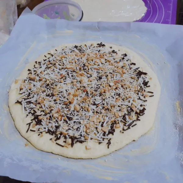 Letakkan 1 lapis roti di atas loyang yang sudah dioles mentega. Taburi dengan meises, keju, kacang, wijen & gula. Letakkan 1 lapis roti lagi, isi kembali denagn bahan isian. Lakukan hingga roti habis. Untuk lapisan teratas biarkan kosong.