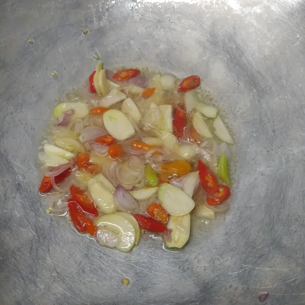 Panaskan minyak goreng, tumis bawang merah, bawang putih dan semua cabe sampai layu dan harum.