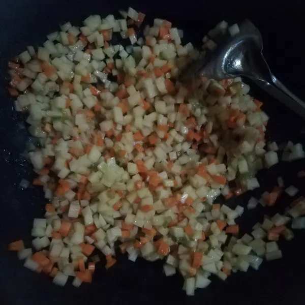 Tumis bawang putih hingga harum, kemudian masukan potongan kentang dan wortel. Aduk hingga tercampur rata.