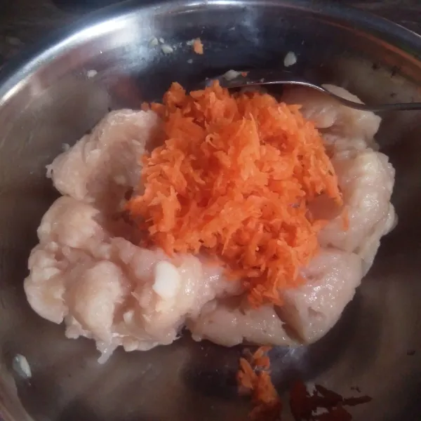 Tambahkan parutan wortel ke dalam adonan isian dimsum tadi, kemudian aduk hingga tercampur rata. Lalu, tambahkan tepung tapioka dan air. Aduk rata.