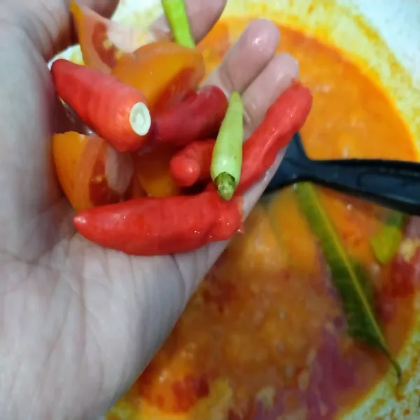 Tambahkan cabe rawit dan tomat, masak hingga mendidih lalu tambahkan kaldu jamur dan garam, cek rasa.