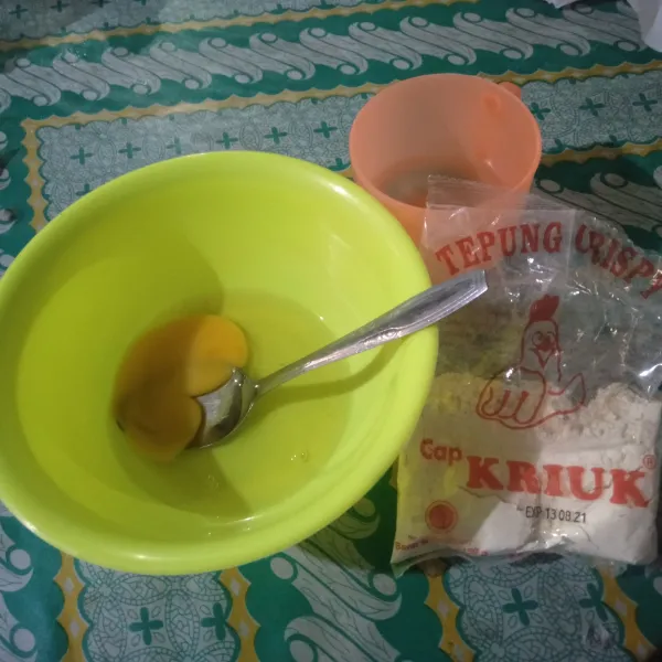 Pecahkan telur dalam mangkuk, lalu tambahkan 1 sdm tepung serbaguna dan tambahkan sedikit air, aduk hingga rata