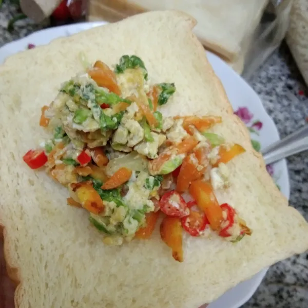 Siapkan roti tawar, beri orak arik telur.