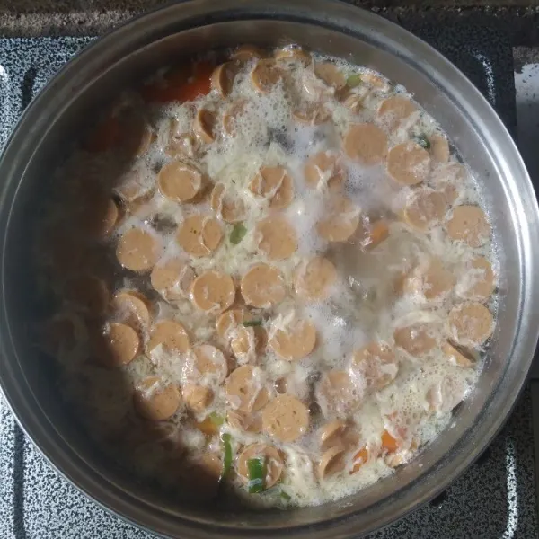 Kocok lepas telur, tuang sedikit demi sedikit ke dalam kuah sop sambil diaduk hingga terbentuk serabut-serabut telur, kecilkan api, masak sebentar.