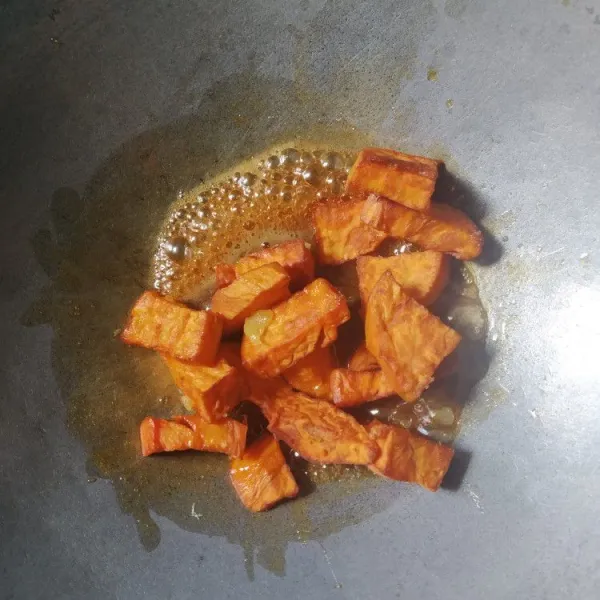 Masukkan ubi goreng, aduk rata, masak dengan api kecil.