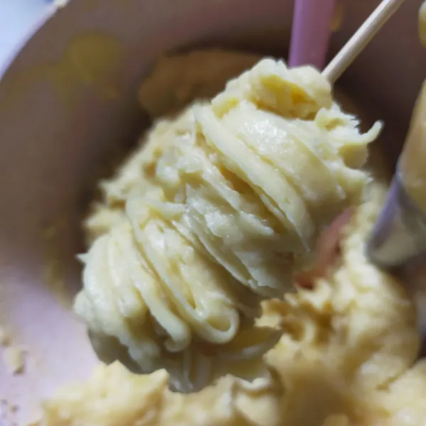 Ambil 1 buah tusukan sosis, semprotkan adonan churros mengelilingi sosis membentuk tampilan spiral.