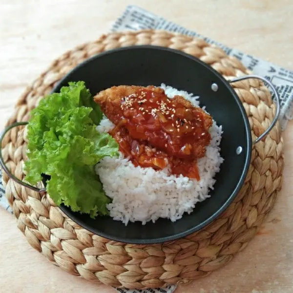 salin dalam wadah saji, tambahkan nasi dan daun selada, sajikan chicken katsu dengan saus barbeque dan taburan wijen sangrai.