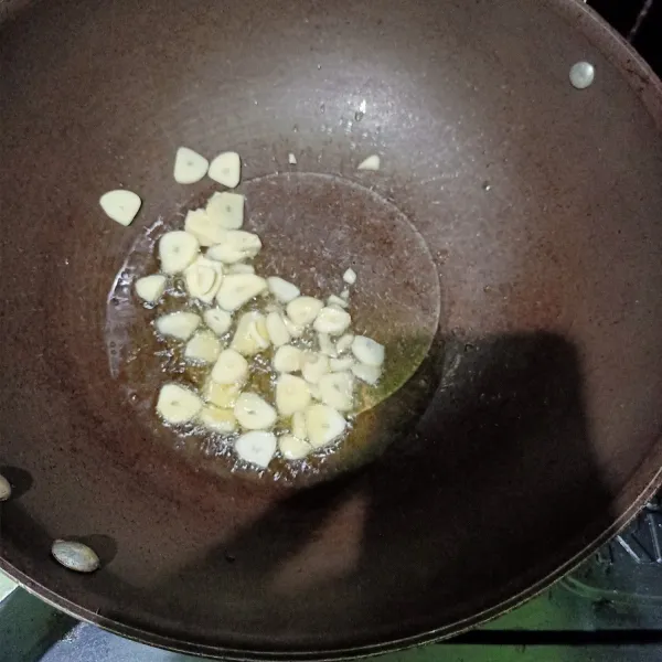 siapkan wajan lalu beri minyak sedikit lalu setelah matang oseng irisan bawang putih sampai tercium harum.