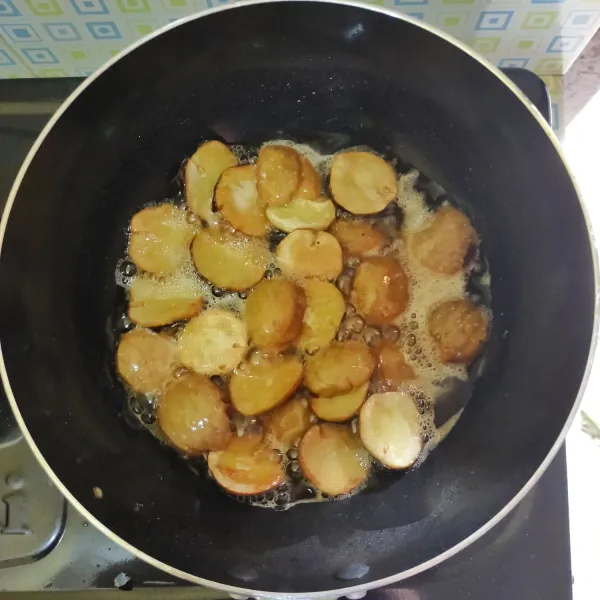 Cuci bersih jengkol lalu belah dua, kemudian goreng jengkol, angkat dan tiriskan.