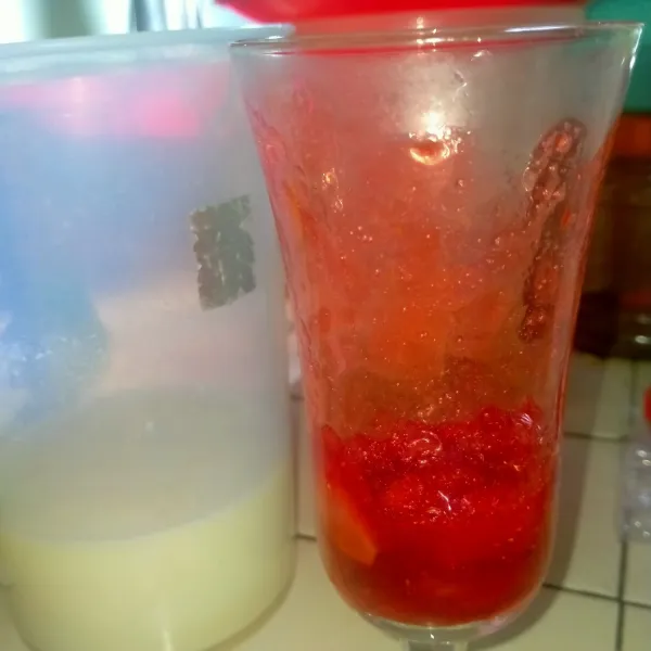 Campurkan air matang dengan SKM. Aduk rata. Kemudian dalam gelas, masukkan srtawberrynya.