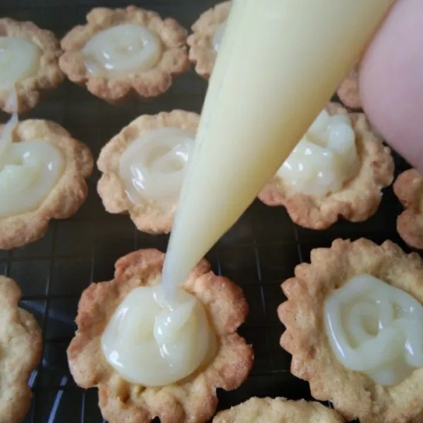 Masukan vla ke dalam piping bag, gunting ujungnya, kemudian semprotkan di atas kulit pie lakukan hingga habis