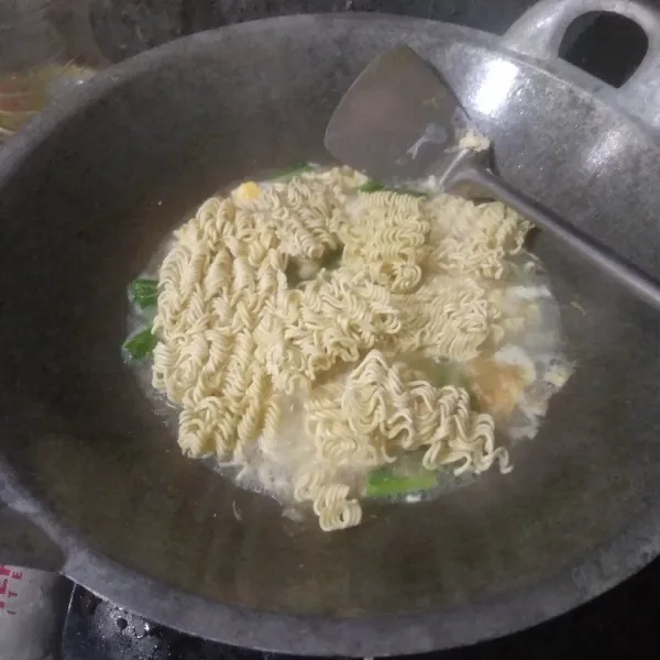 Masukkan mie instan. Masak hingga mie setengah matang.