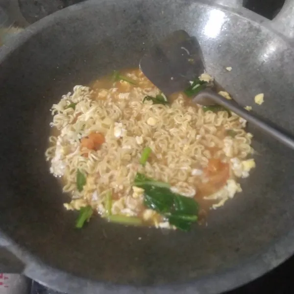 Kecilkan api, masukkan kecap manis, saos tomat, saos sambal dan bumbu mie instan. Aduk rata. Koreksi rasa.