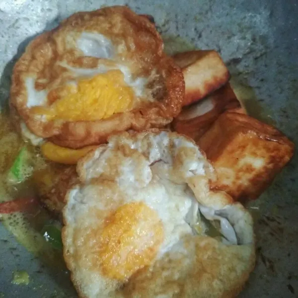 Masukan telur ceplok dan tahu goreng masak hingga telur dan tahu meresap dengan bumbu, sajikan selagi hangat dengan nasi putih hangat .