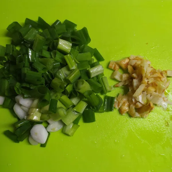 Cincang bawang putih goreng. Iris kasar daun bawang.