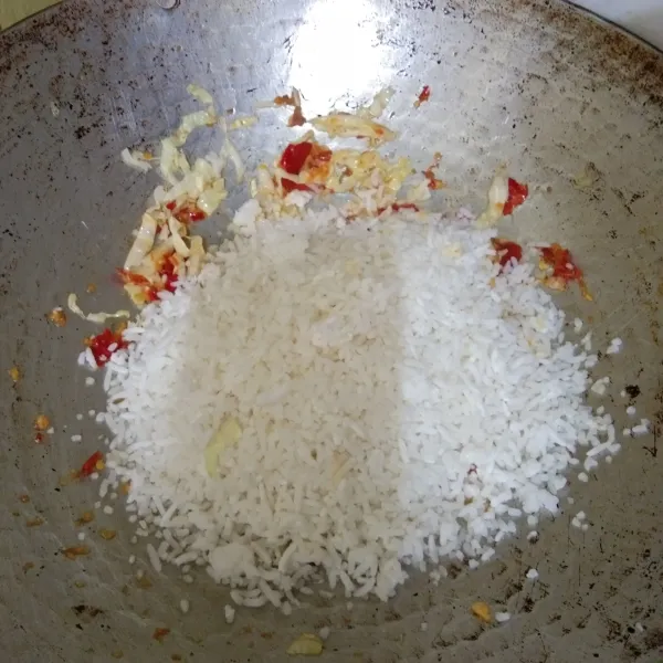 Masukan nasi putih, aduk rata masak hingga nasi panas