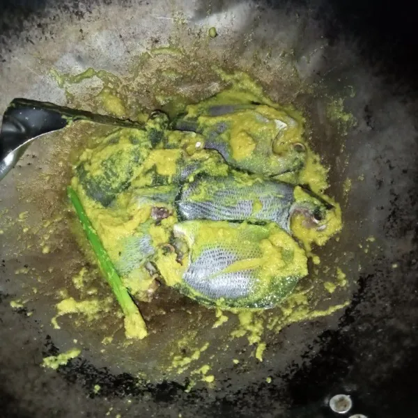 Tumis bumbu halus dan serai hingga bumbu matang dan harum. Masukkan ikan dan aduk rata.