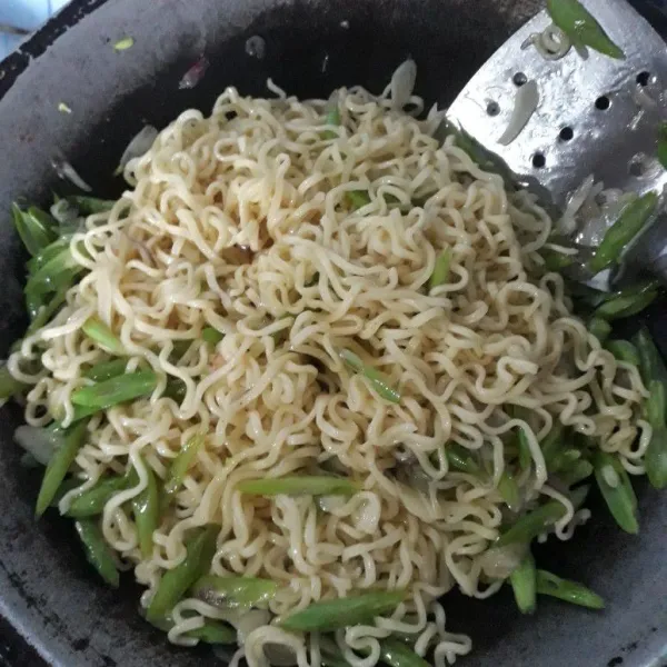 Masukkan mie, aduk rata dengan tumisan buncis. masak hingga buncis matang.