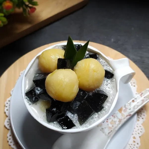 Penyajian: tata batu es dalam gelas saji, tambahkan jelly cincau dan bola-bola tape kau siram dengan kuah santan. Sajikan.