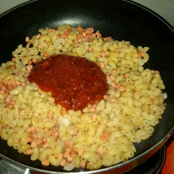 Masukkan macaroni/pasta yang sudah direbut, masukkan juga campuran saus bolognese. Tuang air dan masak sampai tercampur rata. Koreksi rasa dan matikan api.