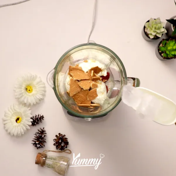 Tambahkan es batu dan saus strawberry ke dalamnya. Kemudian blender hingga halus.