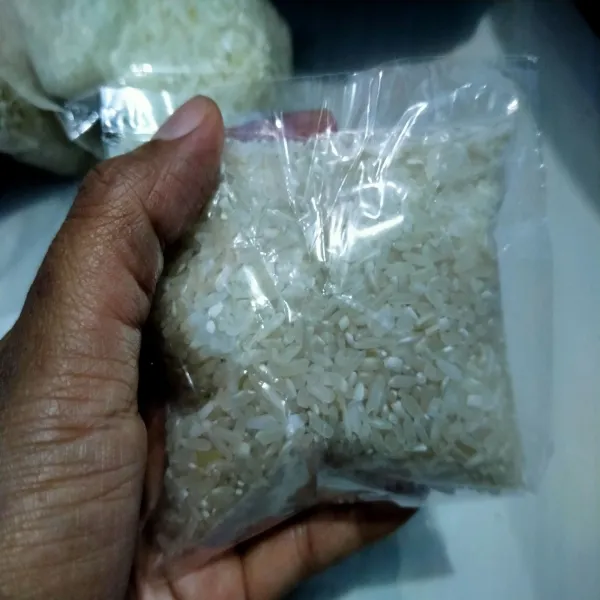 Masukkan beras ke dalam plastik kaca yang bening, takarannya: isi beras setengah bagian dari plastik. Lalu sealer ujung plastiknya, dan tusuk-tusuk dengan lidi.