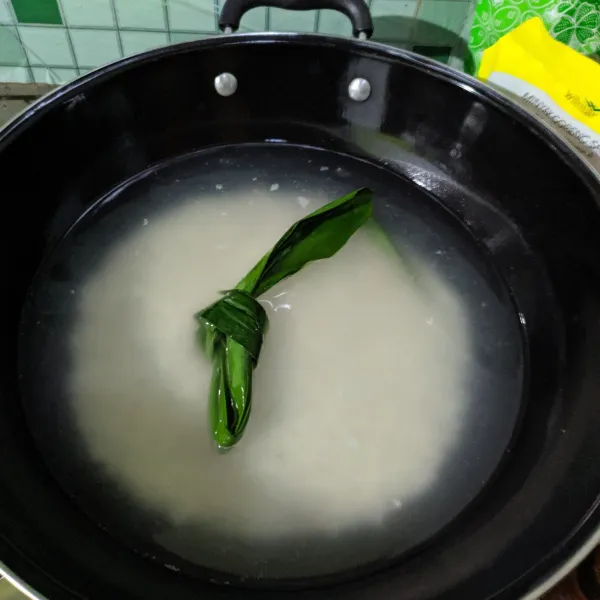 Masukkan beras, daun pandan dan air dalam panci.