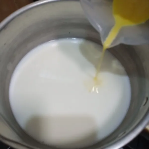 Kocok telur dan gula dalam wadah lain, masukkan dalam panci berisi susu tadi, aduk rata kembali.
