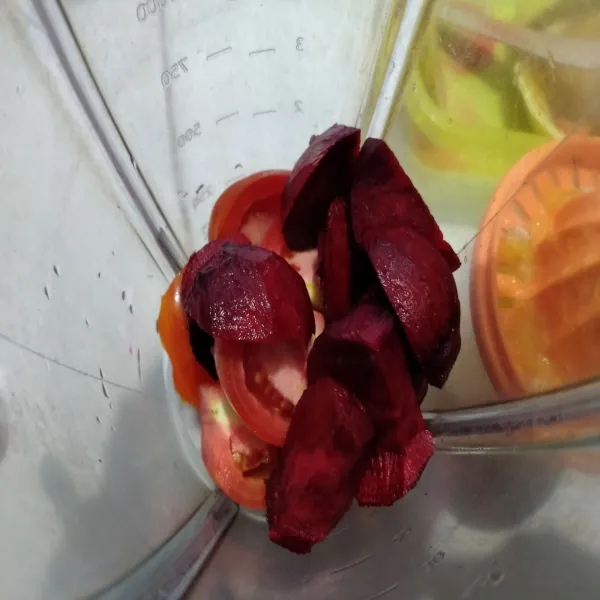 Potong-potong buah tomat dan rootbeet. Masukkan ke dalam blender.