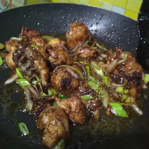 Masukkan ayam goreng, tambahkan air, aduk rata hingga ayam berbalut saos dan kuahnya mengental. Tambahkan garam dan gula, koreksi rasa. Jika sudah pas, masukkan daun bawang, aduk sebentar lalu matikan api. Tiang ke atas piring saji.